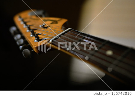 暗闇の中でしっとりした曲を奏でるギター 135742016