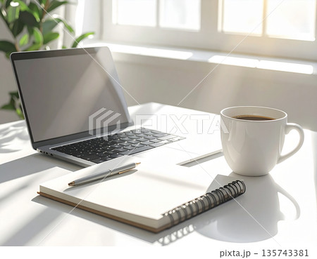 明るい光が差し込む清潔なデスクに置かれたノートパソコンと仕事道具 明るい光が差し込む清潔なデスクに置かれたノートパソコンと仕事道具 135743381