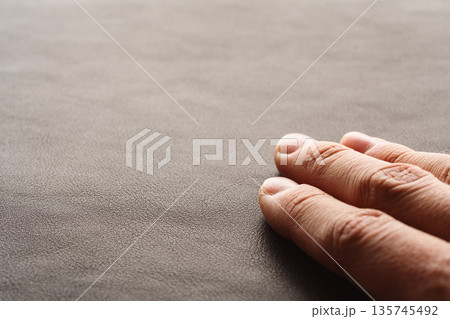 Closeup man hand check dark brown full grain leather 135745492