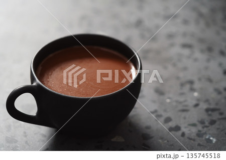 simple cup of hot cocoa drink on terrazzo background simple cup of hot cocoa drink on terrazzo background 135745518