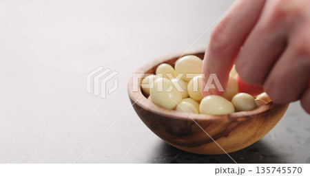 man hand take yogurt covered berries from wood bowl with copy space 135745570