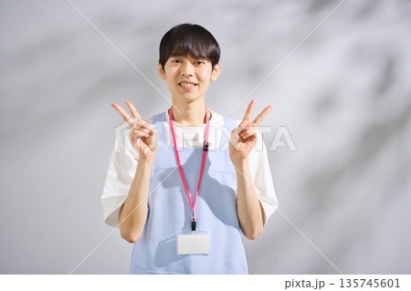 エプロンをした20代男性保育士 135745601