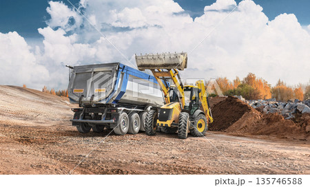 Loader works at construction site, moving dirt and filling a trailer with materials. Equipment rental activities take place under bright skies Loader works at construction site, moving dirt and filling a trailer with materials. Equipment rental activities take place under bright skies 135746588