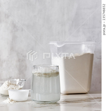 container of protein powder and glass of water container of protein powder and glass of water 135746652