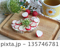 Slice of sourdough bread with slices of fresh radish on the cutting board. 135746781