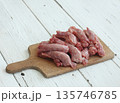 Raw fresh chicken necks on a cutting board. 135746785