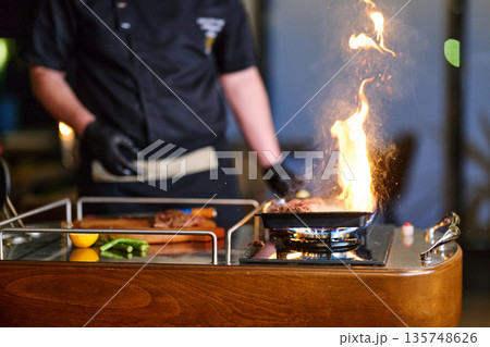 Professional Chef Grilling On a Portable Stove With Dramatic Fire While Cooking Fresh Food 135748626