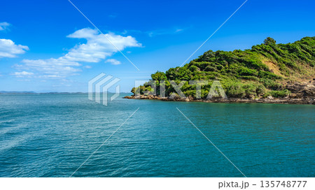 Panoramic view of the lush tropical coastline of Koh Samed island with turquoise waters and a clear blue sky Panoramic view of the lush tropical coastline of Koh Samed island with turquoise waters and a clear blue sky 135748777