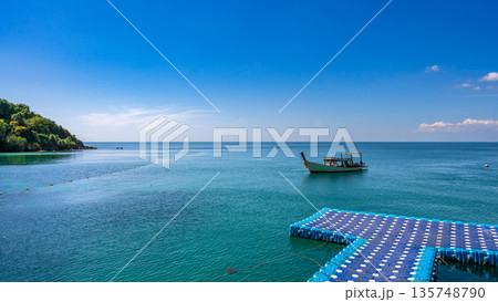 Beautiful coastal views of Koh Samed island featuring speedboats, traditional long-tail boats, and a floating pier on turquoise waters Beautiful coastal views of Koh Samed island featuring speedboats, traditional long-tail boats, and a floating pier on turquoise waters 135748790
