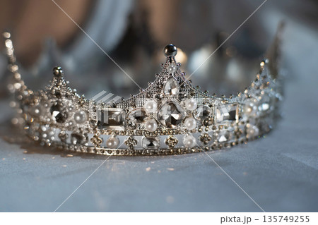 White golden crown with crystals, diamonds on grey background. White golden crown with crystals, diamonds on grey background. 135749255
