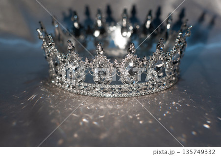White crown with crystals, diamonds on grey background. 135749332