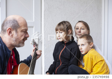 father of real family playing guitar singing, lifestyle people concept 135749498