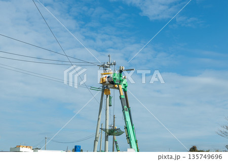 電信柱の上で高所作業をしている作業員 青空と電力会社の人 電信柱の上で高所作業をしている作業員 青空と電力会社の人 135749696