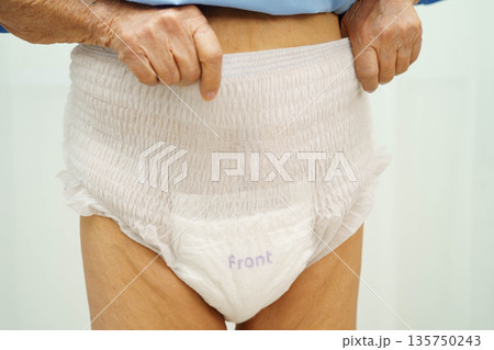 Asian senior woman patient wearing adult incontinence diaper pad in hospital. 135750243