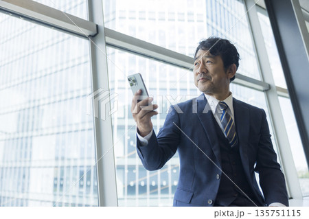 スマホを見るミドル男性 135751115