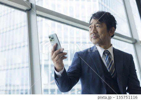 スマホを見るミドル男性 スマホを見るミドル男性 135751116