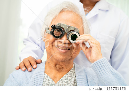 Asian senior woman wearing ophthalmic vision eye test and using optical trial frame. Asian senior woman wearing ophthalmic vision eye test and using optical trial frame. 135751176