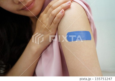 HPV, Human papillomavirus, Asian young woman receiving vaccine with blue bandage. HPV, Human papillomavirus, Asian young woman receiving vaccine with blue bandage. 135751247