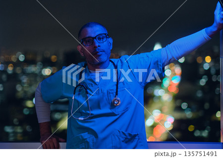 Male medic standing on rooftop city at night Male medic standing on rooftop city at night 135751491