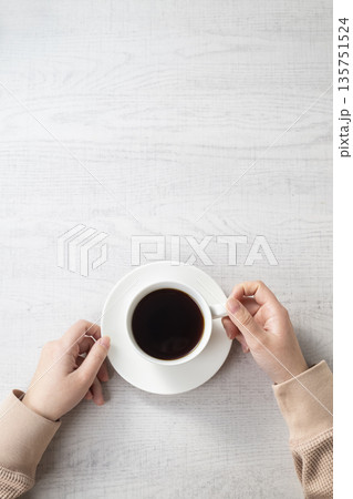 コーヒーカップを持つ女性の手 135751524