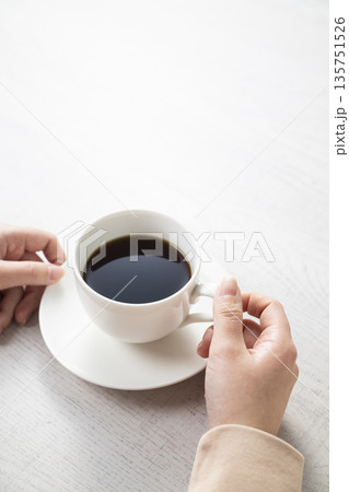 コーヒーカップを持つ女性の手 135751526