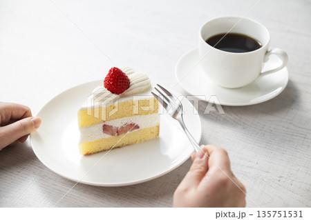 イチゴのショートケーキを食べる女性の手 イチゴのショートケーキを食べる女性の手 135751531