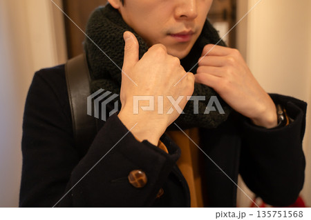 首にマフラーを巻く男性 135751568
