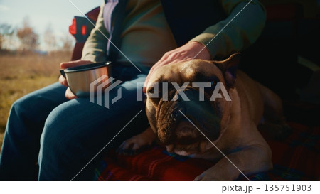 A Serene Moment: A Person Enjoys a Warm Beverage While Relaxing with Their Adorable French Bulldog Amidst Nature's Beauty on a Peaceful Day A Serene Moment: A Person Enjoys a Warm Beverage While Relaxing with Their Adorable French Bulldog Amidst Nature's Beauty on a Peaceful Day 135751903