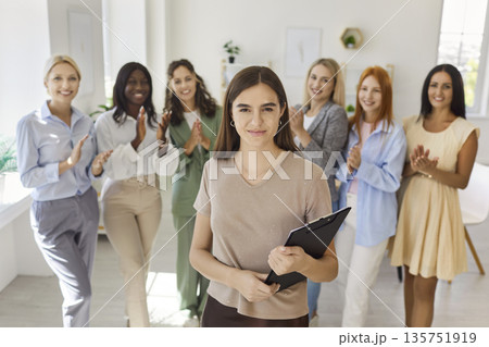 Confident female leader with diverse team applauding during office meeting Confident female leader with diverse team applauding during office meeting 135751919
