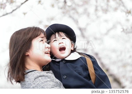 桜と入園式を迎えた3歳の女の子と母親 135752576