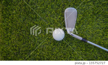Golf grove and golf balls on a green lawn in a beautiful golf course with morning sunshine. Golf grove and golf balls on a green lawn in a beautiful golf course with morning sunshine. 135752727