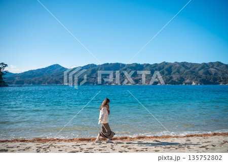 冬に海辺を歩く若い女性 135752802