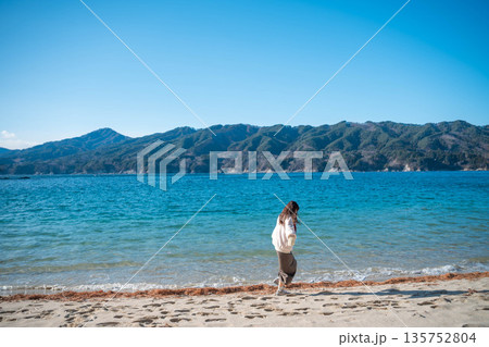 冬に海辺を歩く若い女性 冬に海辺を歩く若い女性 135752804