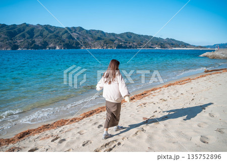 海辺で写真を撮る女性 135752896