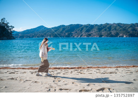 海辺で写真を撮る女性 海辺で写真を撮る女性 135752897