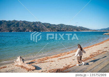 海辺で写真を撮る女性 135752909