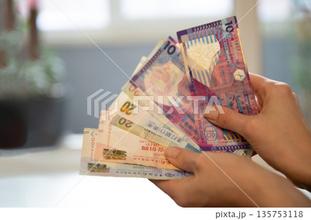 Woman holding Hong Kong dollar banknotes, close up. Cash money exchange and finance concept for banking account and payment. 135753118