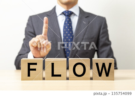 「FLOW」と書かれたブロックとビジネスマン 「FLOW」と書かれたブロックとビジネスマン 135754099