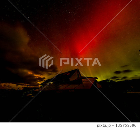 The Aurora Borealis, the northern lights, showing up above bungalow in County Donegal, Ireland 135755396