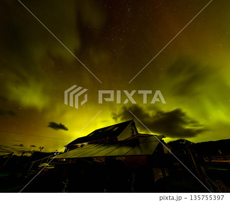 The Aurora Borealis, the northern lights, showing up above bungalow in County Donegal, Ireland 135755397