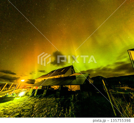 The Aurora Borealis, the northern lights, showing up above bungalow in County Donegal, Ireland 135755398