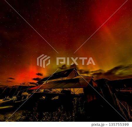 The Aurora Borealis, the northern lights, showing up above bungalow in County Donegal, Ireland 135755399