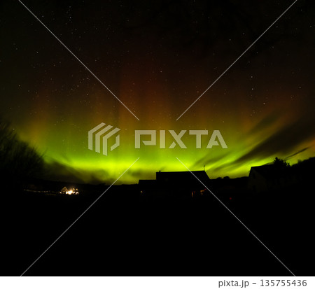 The Aurora Borealis, the northern lights, showing up above bungalow in County Donegal, Ireland 135755436