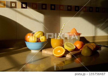 Bright Citrus Breakfast Scene With Fresh Fruit, Orange Juice, And Juicer On Kitchen Counter 135756487
