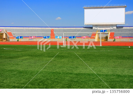 STADIUM - Football field with goal and tablo on blue sky 135756800