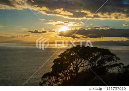 海に沈む夕日とドラマチックな雲の風景 135757060