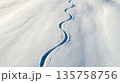 Winding Ski Tracks in Pristine Snowfield at Golden Hour with Serene Journey	 135758756