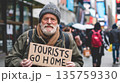 Elderly protester man holds sign with text Tourists Go Home, demonstration against overtourism in touristic european city 135759330