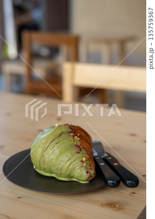 Croissant with pistachio served on plate, on the wooden table Croissant with pistachio served on plate, on the wooden table 135759367