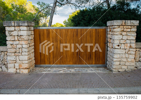 Big wooden automatic entry gate in the house in Spain 135759902
